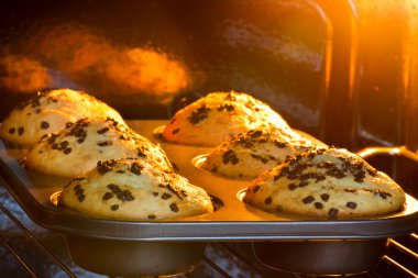 Baking tray with muffins in hot oven clipart