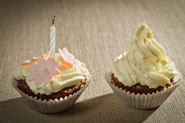 Zwei Schokoladenmuffins mit Kerze und Vanillecreme — Stockfoto
