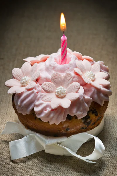 Muffin avec bougie allumée, crème aux fraises et arc — Photo