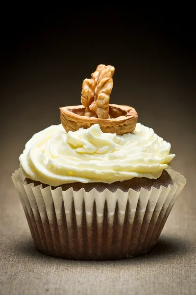 Chocolade muffin en vanille crème met walnoot kijkt op boot — Stockfoto