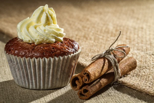 Choklad muffin med vanilj grädde och kanel bark — Stockfoto