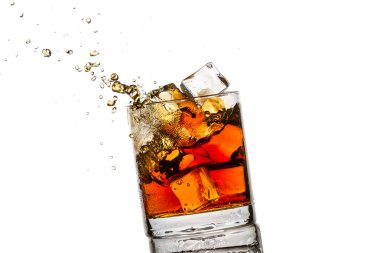 Splash in glass with whisky and ice cubes on white background clipart