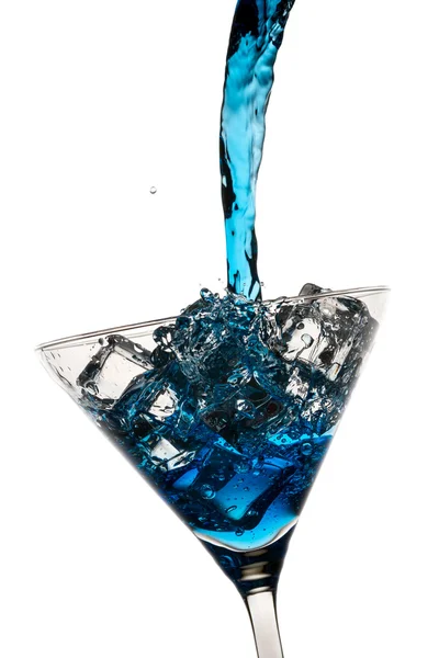 蓝利口酒浇入马提尼杯冰块在白 — 图库照片
