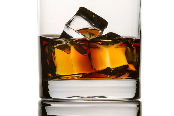 Closeup brandy s skla a kostky ledu na bílém pozadí — Stock fotografie