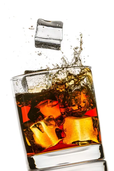 Splash em um copo de uísque no fundo branco — Fotografia de Stock