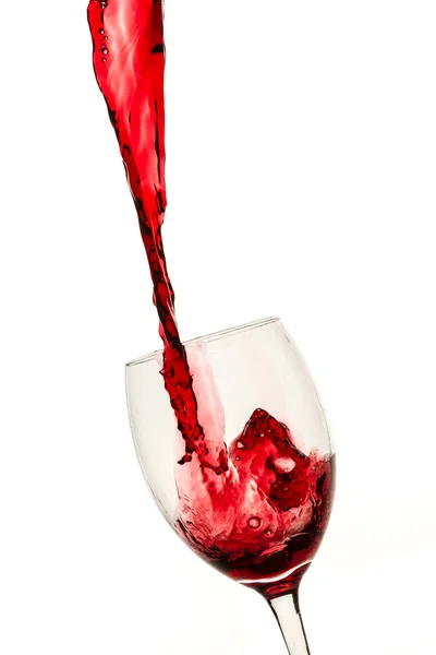 Szklane wypełnione duży strumień czerwone wino na białym tle — Zdjęcie stockowe