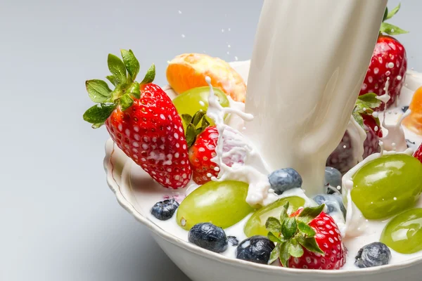 Stock image Splash of milk pushes fresh fruit from the bowl