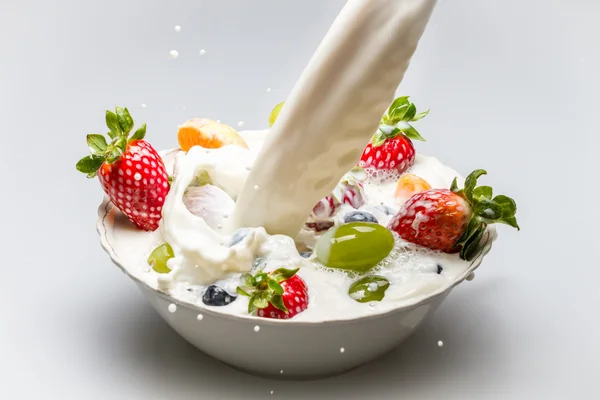 Milk pouring into fresh fruits — Stock Photo, Image