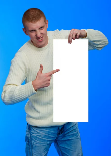 Handsome young man holding big white blank — Stock Photo, Image