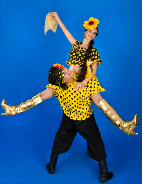 Молодая пара в национальных костюмах России танцует в студии — стоковое фото