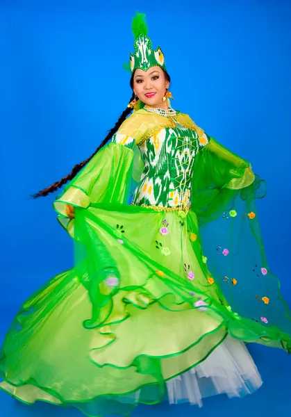 Веселая, красивая девушка в традиционном платье танцует узбекский танец — стоковое фото