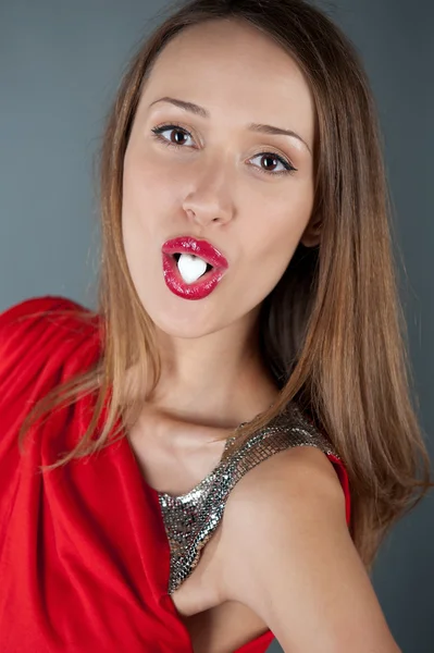 입에서 하트 모양의 설탕과 함께 섹시 한 여자 — 스톡 사진