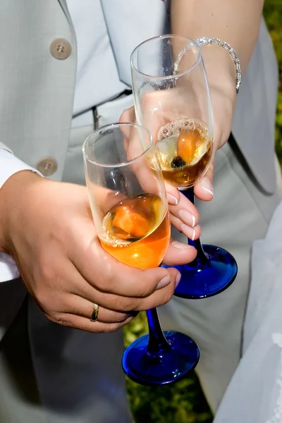 A glass of champagne in hand with children — Stock Photo, Image