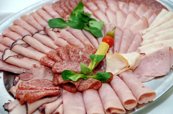 Garnished dish - cheese, ham, salami — Stock Photo, Image