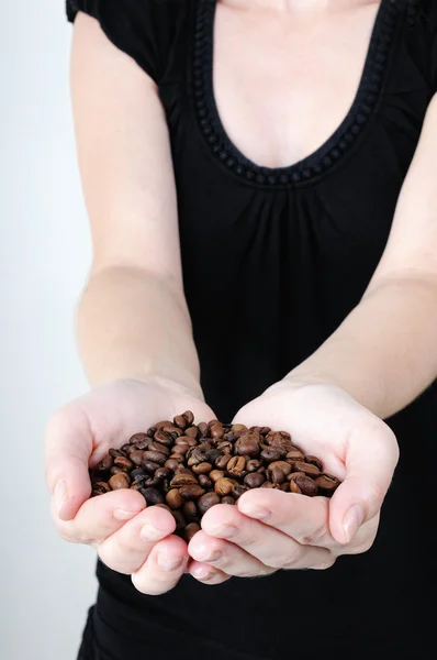 Mujer cogida de la mano en granos de café — Foto de Stock