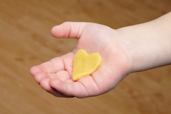 Cuore tagliato fuori dalla pasta sulla mano del bambino — Foto Stock