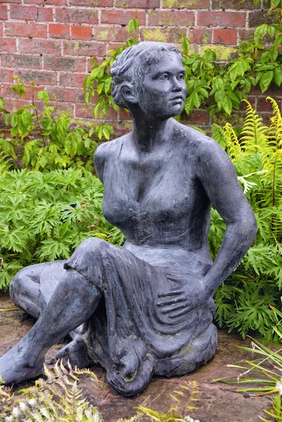 Dziewczyna siedzący statua w ogrodzie — Zdjęcie stockowe