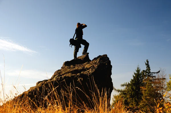 Силуэт фотографа на скале осенью — стоковое фото