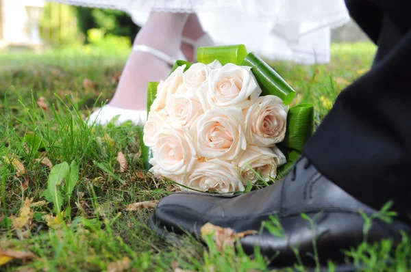 Brautstrauß aus Rosen mit dem Brautpaar — Stockfoto