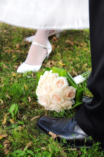 Brautstrauß aus Rosen mit dem Brautpaar — Stockfoto