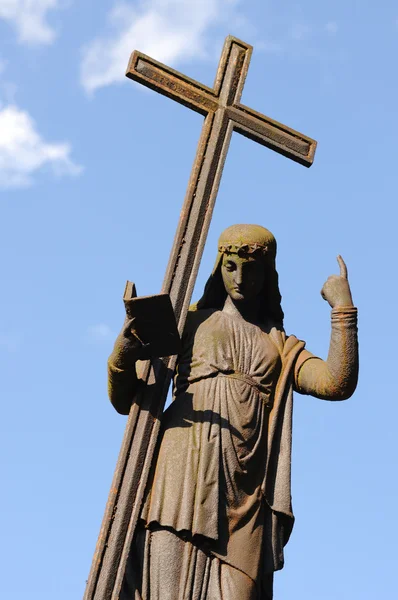 Figura com uma cruz no céu azul no cemitério Svitavy — Fotografia de Stock