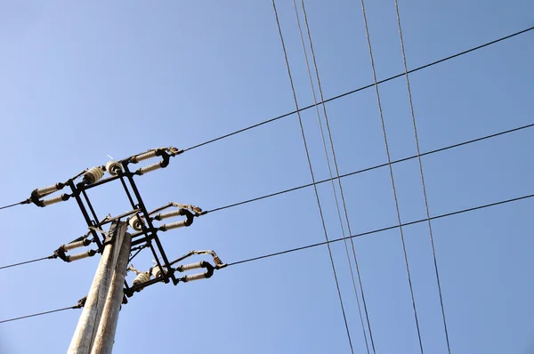 stock image Electrical tower in field under blue sky