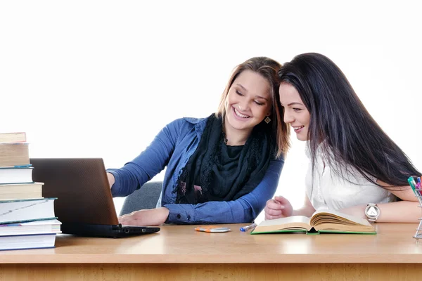Meisje student leest een boek en de laptop aan de tafel, geïsoleerd op wit — Stockfoto