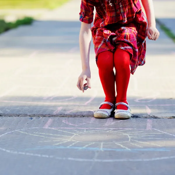 Dítě dívka hraje peklo na asfaltu — Stock fotografie