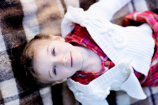 Enfant fille couché sur plaid dans un jardin — Photo