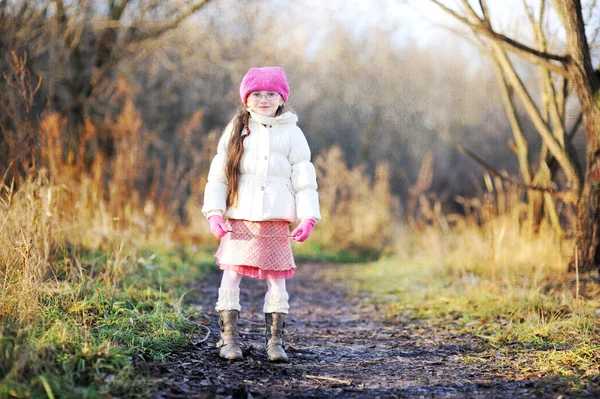 Klein meisje dragen van roze GLB wandelingen langs de weg — Stockfoto