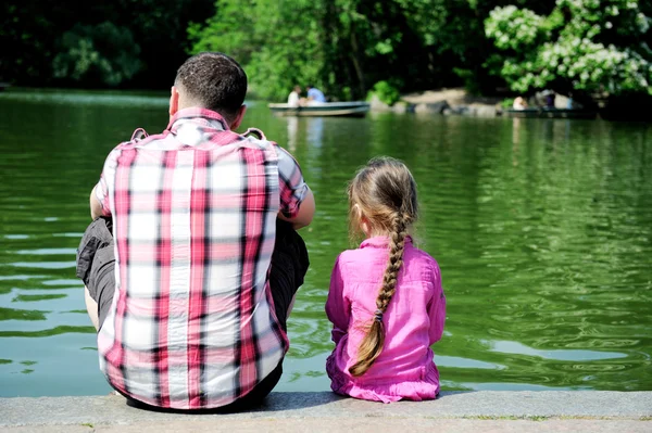 Mladý otec a jeho dcera nedaleko rybníka — Stock fotografie