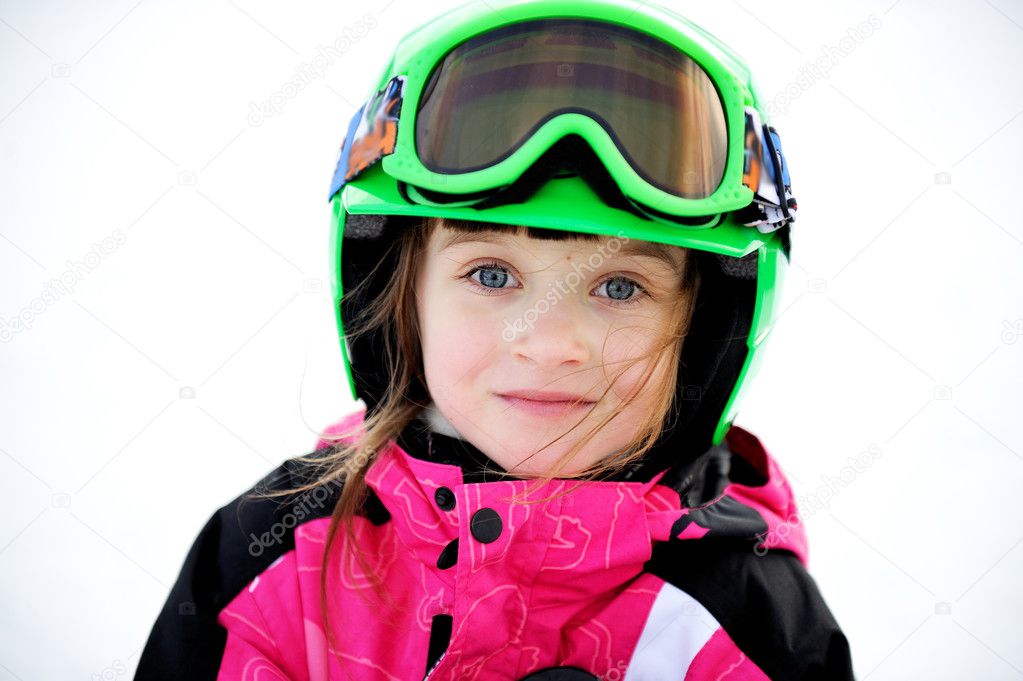 Little child girl in ski helmet and goggles