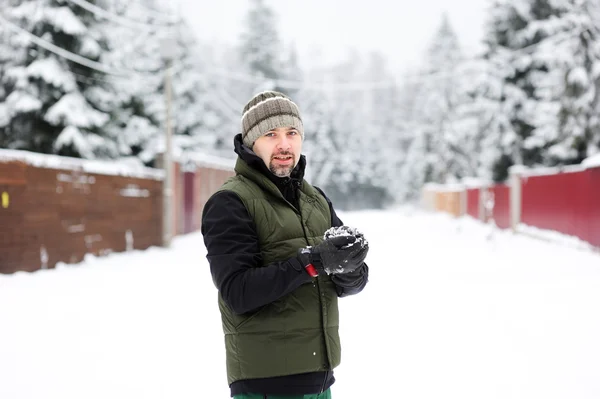 Jonge man een sneeuwbal voorbereiden — Stockfoto