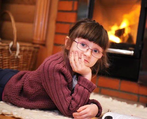 Portrait of a child girl in front of fireplace — Stock Photo, Image