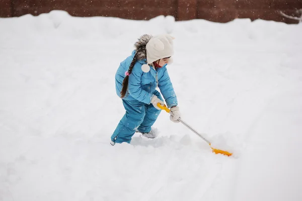 Cute toddler girl in snowsuit cleaning the road — Stock Photo, Image