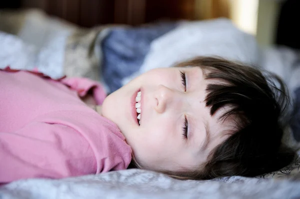 Rozkošná holčička odpočívá v posteli — Stock fotografie
