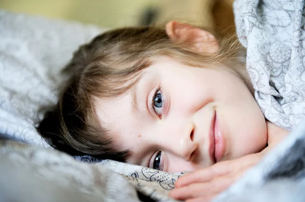 Bedårande liten flicka vilar i sängen — Stockfoto