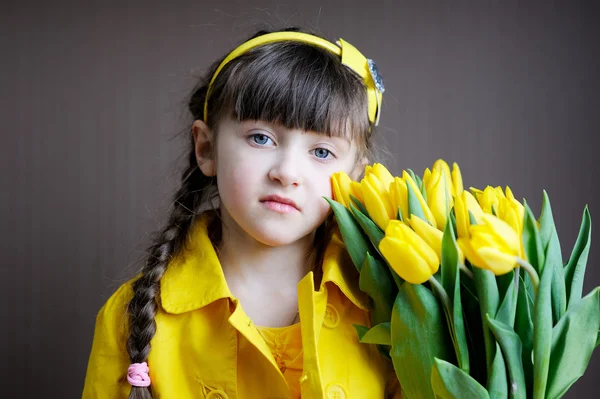 Muchacha del niño soleado con ramo de tulipanes amarillos — Stockfoto