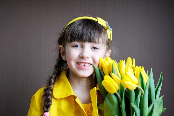 阳光儿童女孩与花束的黄色郁金香 — 图库照片