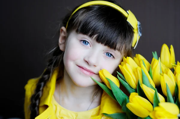Ηλιόλουστη παιδί κορίτσι με μπουκέτο των κίτρινων τουλιπών — Φωτογραφία Αρχείου