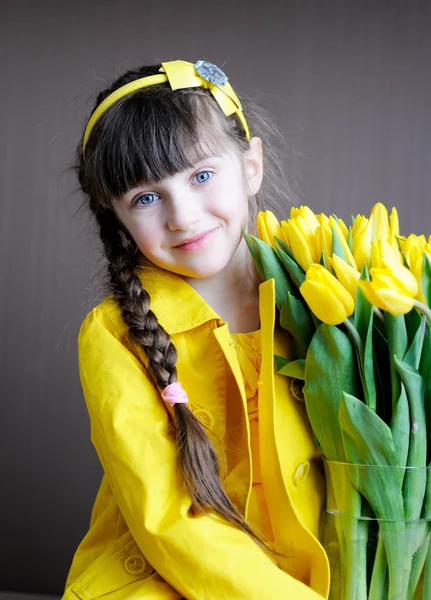 Menina ensolarada com buquê de tulipas amarelas — Fotografia de Stock