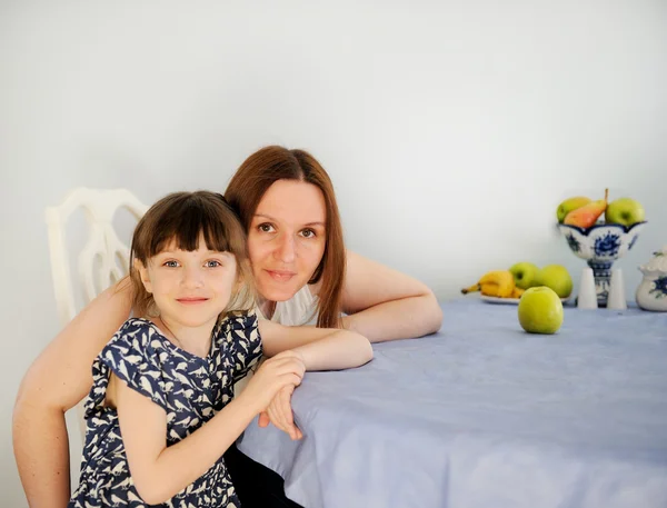 Joven madre con su hija pequeña en la cocina —  Fotos de Stock