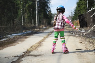 Sporty child girl on roller skates clipart