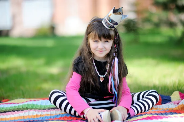 Belleza pequeña princesa sentada al aire libre en manta —  Fotos de Stock