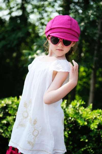 Красавица маленькая девочка в белом платье позирует наши двери — стоковое фото