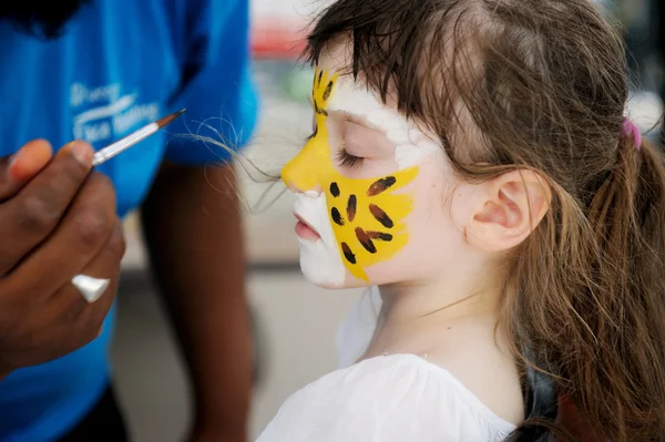 Cute little girl has her face painted — Stock Photo, Image