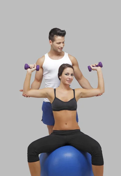 Erkek eğitmen ile birlikte bir kadın egzersiz — Stok fotoğraf