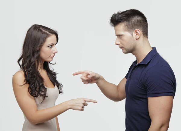 Couple pointing to each other in studio environment