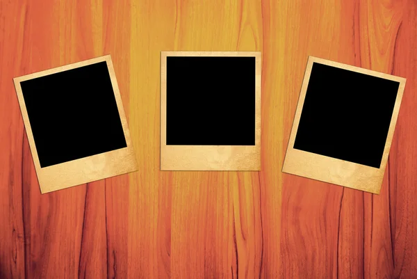 Leere Instant-Fotorahmen auf altem Holzgrund. — Stockfoto