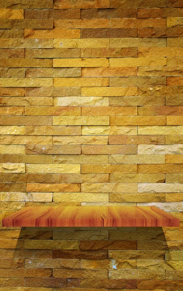 Empty wood shelf on stone wall — Stock Photo, Image